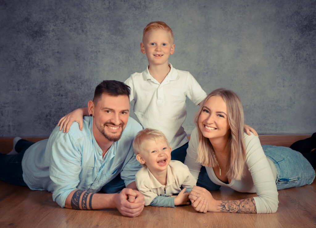 glückliche Familie liegt auf Holzfußboden